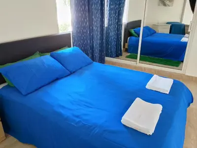 a blue bed in a room with a mirror at Residencias Turísticas Espinosa in Villas del Mar