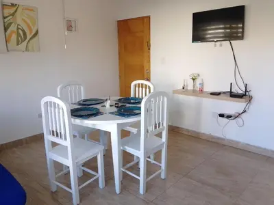 a white table with four chairs and a television at Residencias Turísticas Espinosa in Villas del Mar