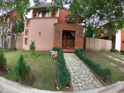 two children standing in a yard in front of a house at Villa 3 Habitaciones con piscina in Jarabacoa