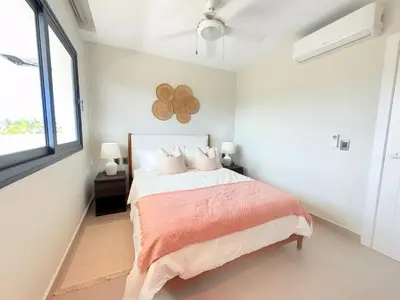 a bedroom with a bed and a window at Gardenia Beachside Living in Punta Cana