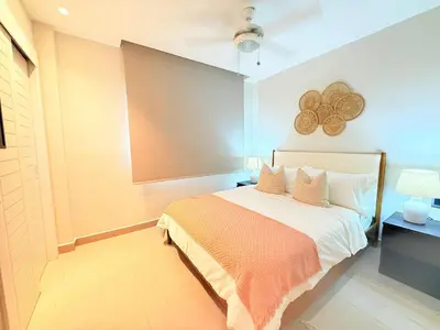 a bedroom with a bed with an orange blanket at Gardenia Beachside Living in Punta Cana