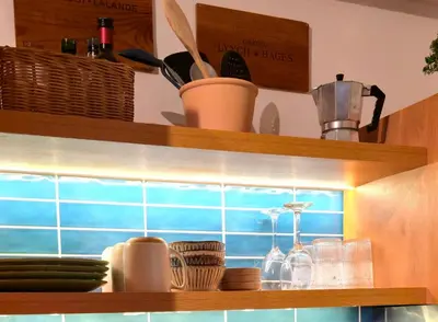 a kitchen shelf with dishes and utensils on it at Casa Lio in Boca Chica