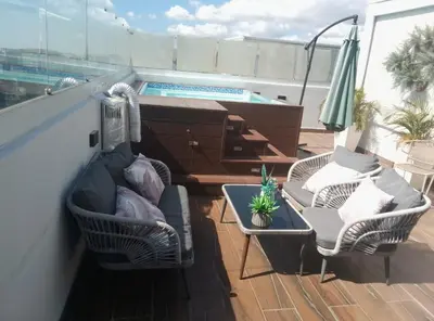 a balcony with two chairs and a table and a pool at Sky 01 M11 in Santo Domingo