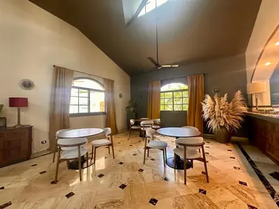 a room with two tables and chairs and windows at Oris Chic & Tropical Suite, Breakfast in Las Terrenas