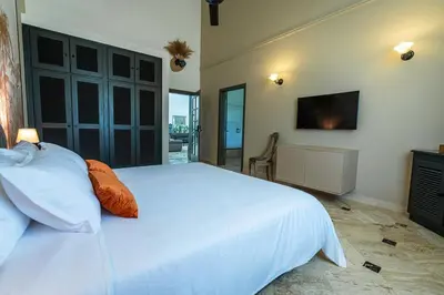 a bedroom with a large white bed and a television at Oris Chic & Tropical Suite, Breakfast in Las Terrenas