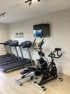 a gym with three exercise bikes and a tv at Civil tower oceance in Santo Domingo