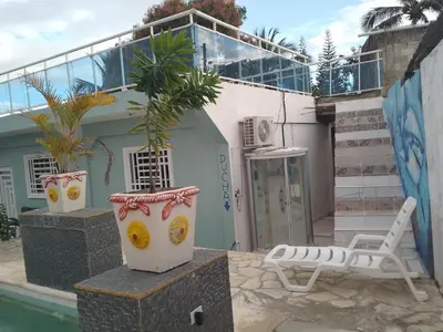 a house with a pool and a chair and plants at Brisa del mar in Boca Chica