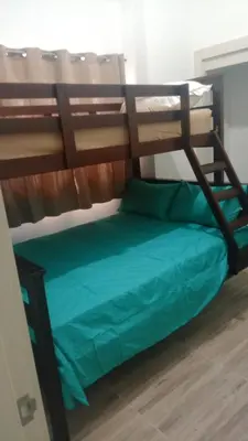 a bunk bed in a room with a green bed at Comfortable oceanfront apartment on Av España in La Francia