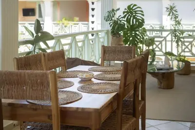 a dining room table with chairs and a table with plates on it at Cultrera 1 in Las Terrenas