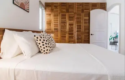 a bedroom with a white bed with pillows at Cultrera 1 in Las Terrenas