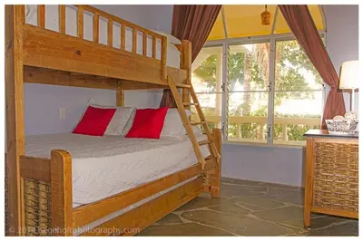 a bedroom with a bunk bed with a red pillow at Villa Dawn, Bahia de Arena in Cabarete