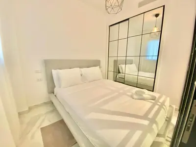 a small bedroom with a white bed with a mirror at 1B Fantasy Lodge @t Canabay Private Pool and beach in Punta Cana