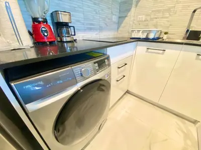 a kitchen with a washing machine under a counter at 1B Fantasy Lodge @t Canabay Private Pool and beach in Punta Cana
