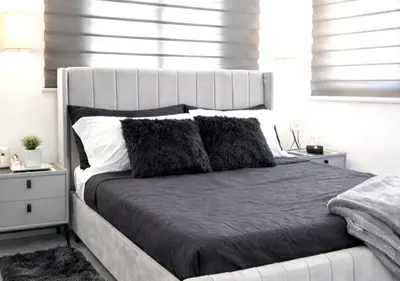 a bedroom with a large bed with a white headboard at Comfy & Secure Modern 2BR Apartment just 5 minutes from Airport in Boca Chica in Boca Chica