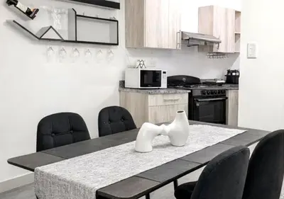 a kitchen with a table with chairs and a microwave at Comfy & Secure Modern 2BR Apartment just 5 minutes from Airport in Boca Chica in Boca Chica