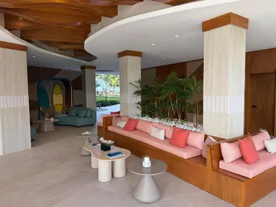 a living room with pink couches and tables at Stunning oceanfront apartment in Encuentro at The Wave in Cabarete