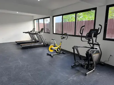 a gym with cardio equipment in a room with windows at Stunning oceanfront apartment in Encuentro at The Wave in Cabarete