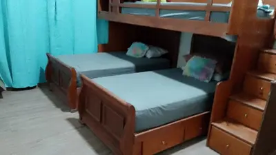 two bunk beds in a room with blue curtains at Alto Nuevo