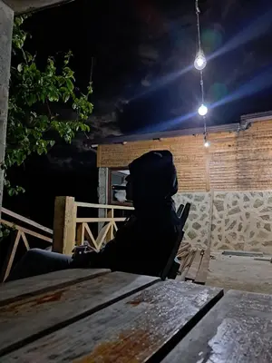 a person sitting at a table at night at Alto Nuevo