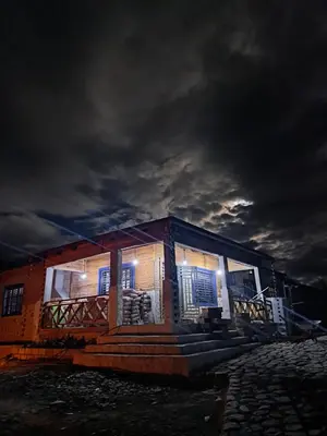 a house lit up at night with a cloudy sky at Alto Nuevo