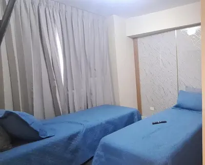 a bedroom with two beds with blue sheets and a window at Exclusive apartment in SDE in Juan López