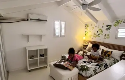 two children sitting on a bed reading books at Habitat Samaná Apartments - Coral Samanà