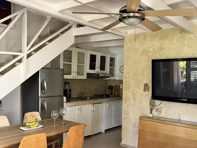 a kitchen with a dining table and a ceiling fan at Habitat Samaná Apartments - Coral Samanà