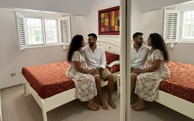 a group of three people sitting on a bed at Habitat Samaná Apartments - Coral Samanà