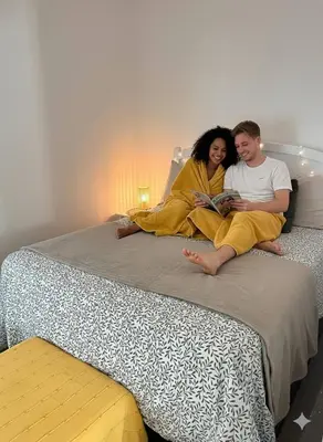 a man and woman sitting on a bed reading at Comfortable stay for 4 people in Las Galeras