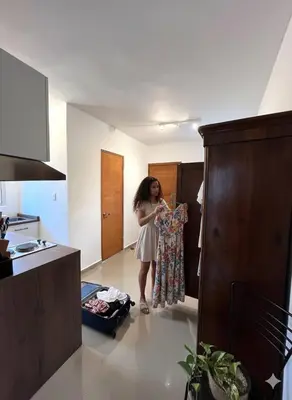 a woman standing in a kitchen holding a dress at Comfortable stay for 4 people in Las Galeras