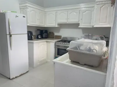 a kitchen with white cabinets and a white refrigerator at Casa a solo 30 minutos de la playa