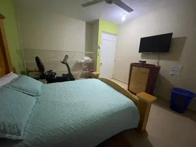 a bedroom with a bed and a flat screen tv at Casa a solo 30 minutos de la playa