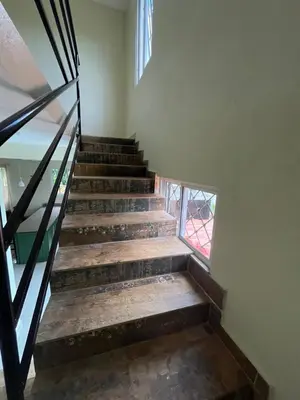 a set of stairs in a building with a window at Pequeña villa de María in Villa Mella