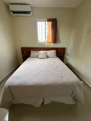 a bedroom with a large bed with a window at Pequeña villa de María in Villa Mella