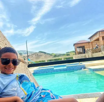 a young boy sitting in a chair next to a swimming pool at Alto Nuevo