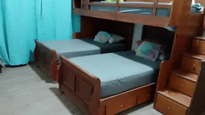 two bunk beds in a room with blue curtains at Alto Nuevo