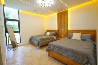 a bedroom with two beds and a window at Modern Villa with a 15m Lap Pool, Cabarete in Cabarete