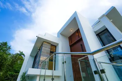 a white house with a wooden door at Modern Villa with a 15m Lap Pool, Cabarete in Cabarete