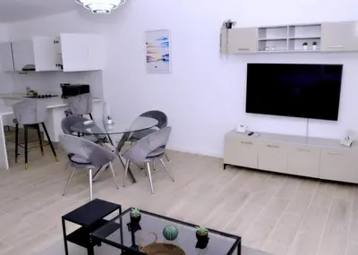 a living room with a tv and a table and chairs at Peaceful 2BR Retreat with Pool, Paddle Court & Private Beach Access in Punta Cana