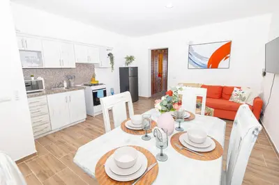 a kitchen and living room with a table and chairs at Caribbean Escape 1BR at Paraiso Bayahibe in Bayahibe