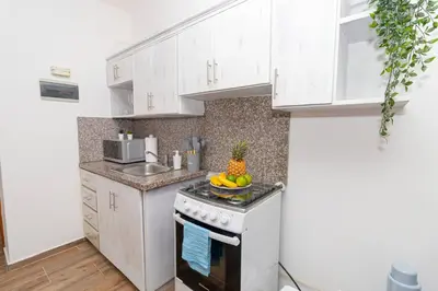a kitchen with white cabinets and a bowl of fruit on the stove at Caribbean Escape 1BR at Paraiso Bayahibe in Bayahibe