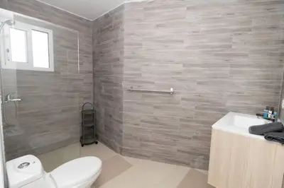a bathroom with a toilet and a sink and a shower at Caribbean Getaway 2BR at Caribbean Rose Bayahibe in San Rafael del Yuma