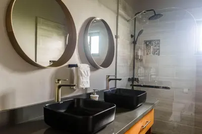 a bathroom with a black sink and two mirrors at SwellHouseVilla in Cabrera