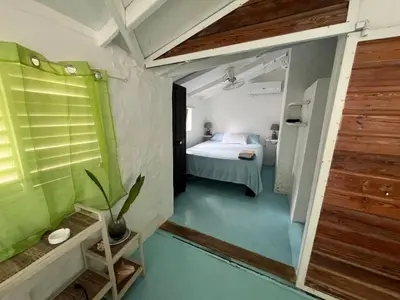 a small room with a bed and a bathroom at Hostel La Bohème in Las Terrenas
