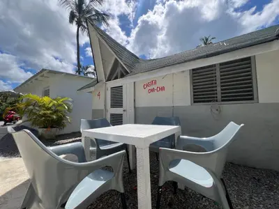 a white table and chairs in front of a building at Hostel La Bohème in Las Terrenas