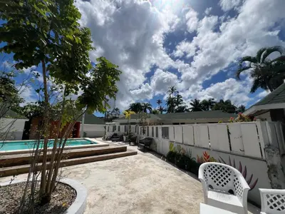a house with a swimming pool and a fence at Hostel La Bohème in Las Terrenas