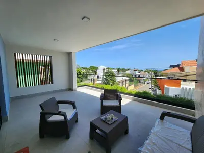 a living room with a large window with chairs and a couch at Cigua Palmera 42 in Puerto Plata