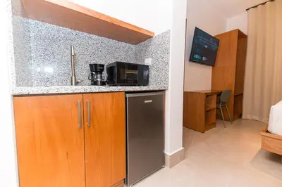 a kitchen with a sink and a microwave at PF Hotel in San Felipe de Puerto Plata