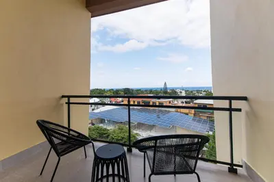 a balcony with chairs and a view of a building at PF Hotel in San Felipe de Puerto Plata