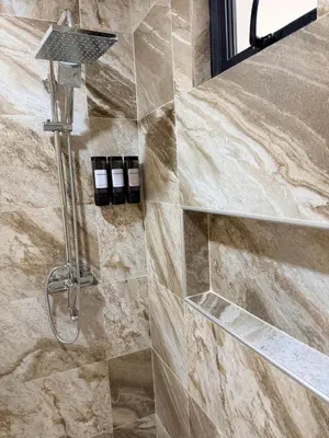 a shower in a bathroom with a stone wall at PF Hotel in San Felipe de Puerto Plata